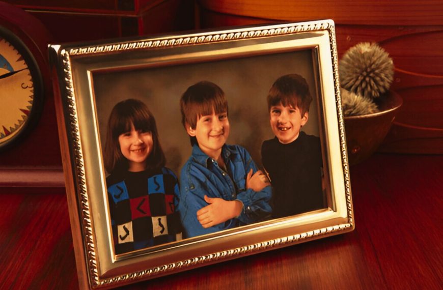 childhood ornate gold frames Framed photo on wooden desk of three smiling children