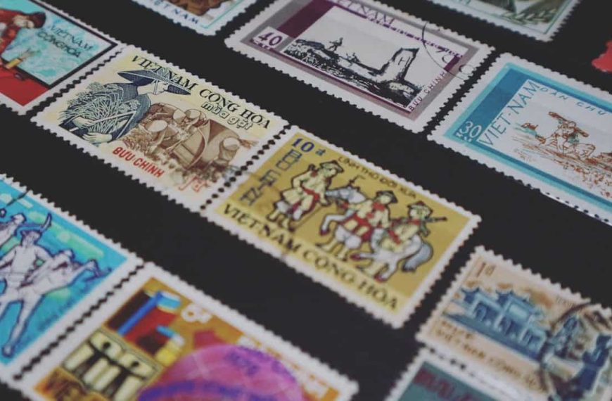 Assorted vintage Vietnamese postage stamps, arranged on a black display background, featuring illustrations of soldiers, cultural scenes, historic landmarks, and traditional clothing, with varied colors including blue, yellow, red, and white