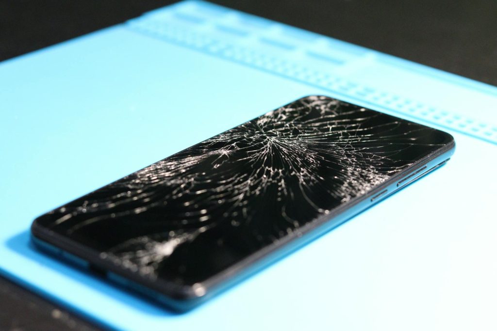 Close-up of a Broken Smartphone on Blue Background