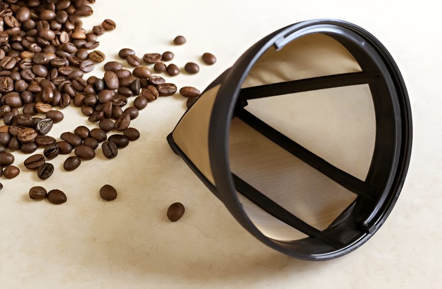 Reusable metal mesh coffee filter for drip coffee maker. Permanent basket coffee filter on white background. Accessories for coffee machines close-up.