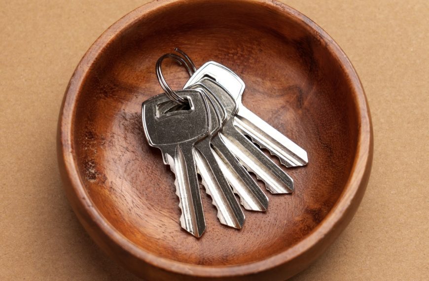 valet tray, brown leather, car keys, house keys, metal keychain, wooden surface, organized entryway accessory