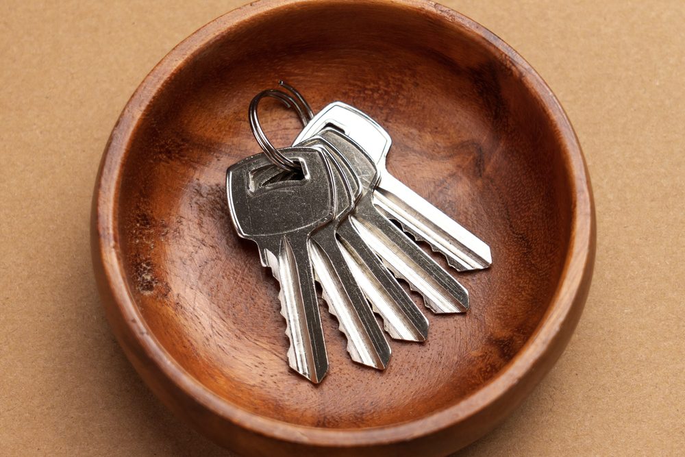 valet tray, brown leather, car keys, house keys, metal keychain, wooden surface, organized entryway accessory