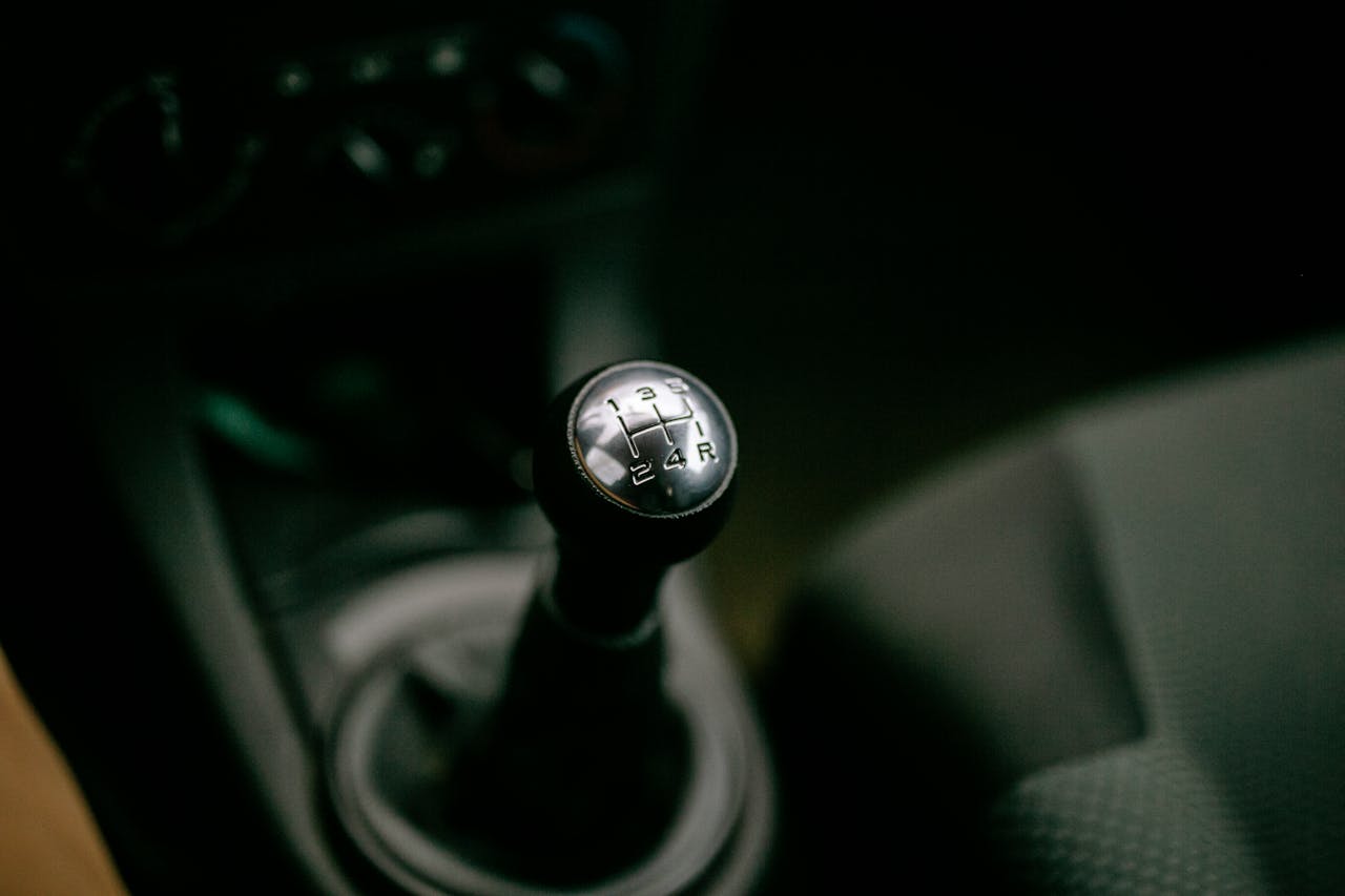 Manual gear shift knob in a car, 5-speed pattern with reverse, black interior, close-up view