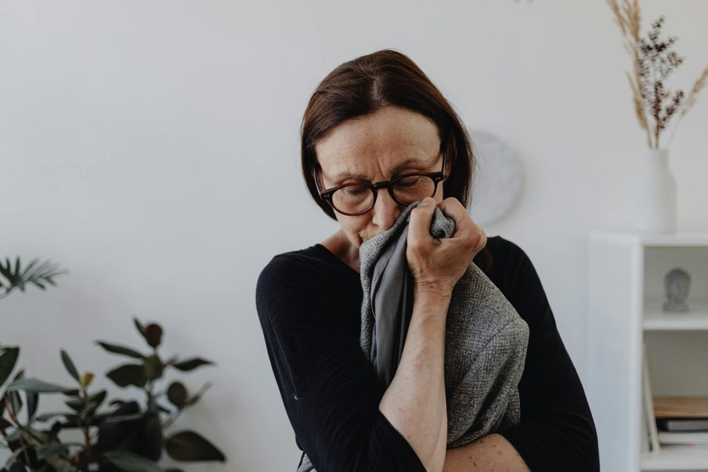 A Sad Woman in Black Top Holding a Gray Cloth