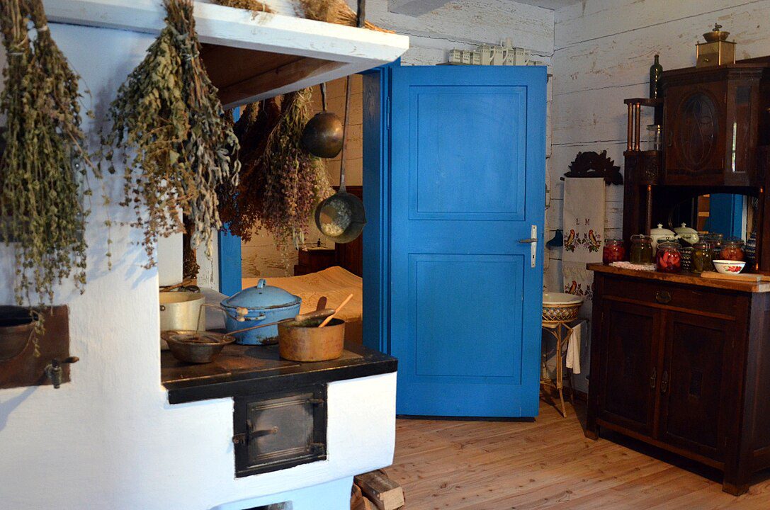  rustic kitchen interior, hanging dried herbs, blue wooden door, vintage wooden furniture, ceramic pots on shelves, cozy and traditional atmosphere