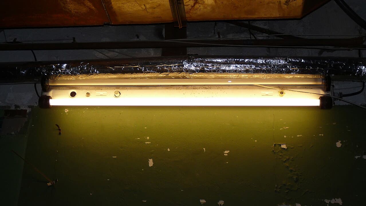 old basement lighting, neglected industrial space, temporary repair setup, outdated workshop environment, maintenance issue in storage room, prepping area for renovation