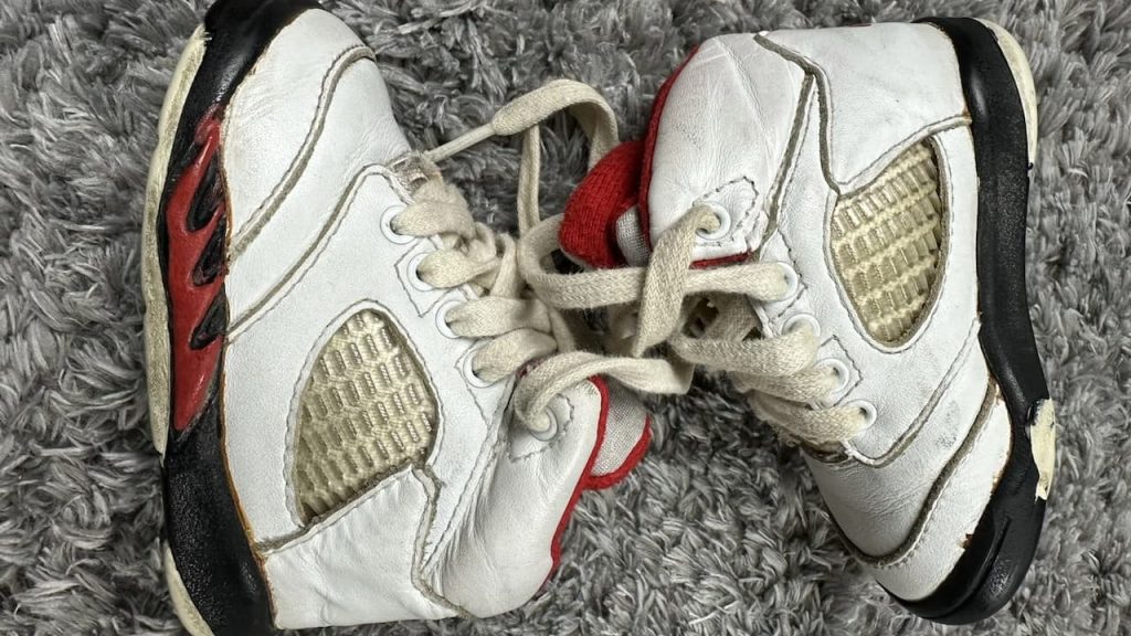 1980s Nike Air Jordan sneakers, high-top design, leather construction, bold color contrast, iconic Nike swoosh, visible Air sole unit, vintage basketball shoes