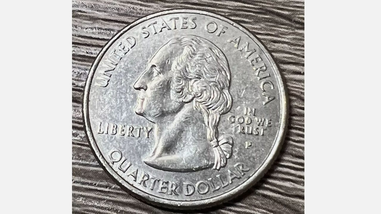 Close-up of a U.S. quarter showing George Washington and the text "In God We Rust"
