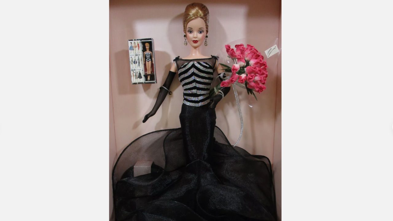 40th Anniversary Barbie doll in black glittery gown, holding pink flowers, wearing elegant earrings, boxed with commemorative mini Barbie figure insert
