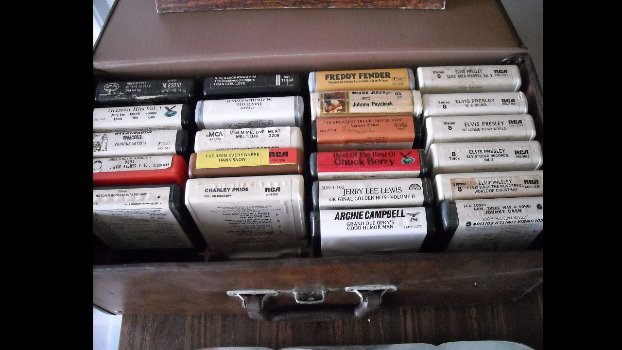 Box of vintage 8-track tapes neatly arranged, featuring artists like Elvis Presley, Johnny Cash, Chuck Berry, and Jerry Lee Lewis