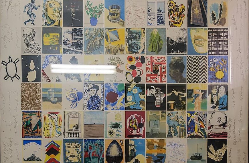 Framed collection of signed band posters, arranged in a grid layout, showcasing various bands, album art, and autographs, behind reflective glass