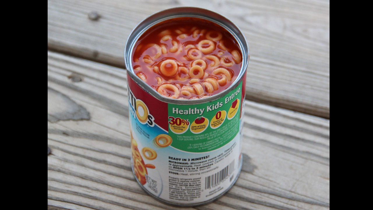 Open can of spaghetti rings in tomato sauce labeled “Healthy Kids Entrée” on wooden surface