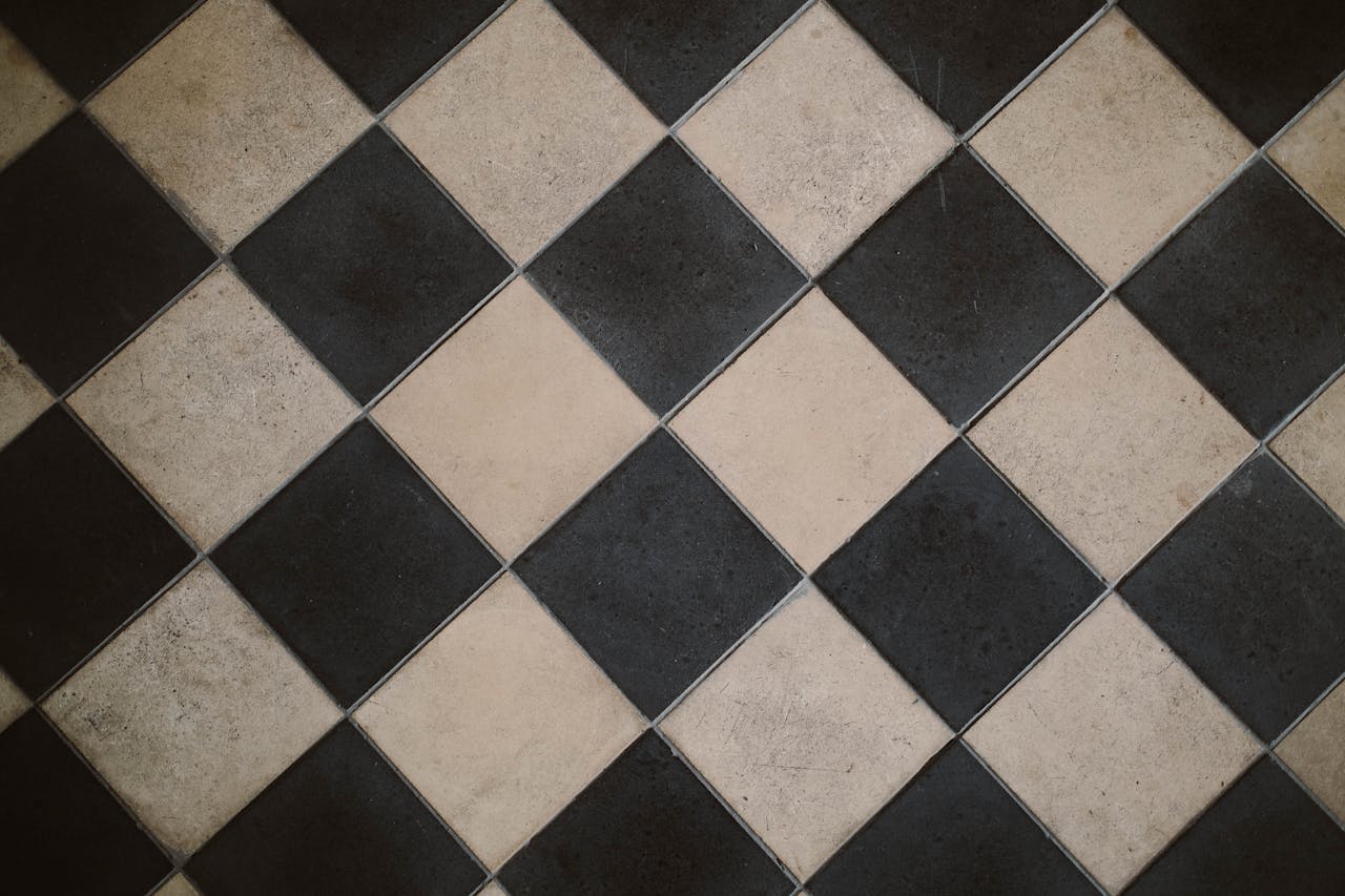 Diagonal black and beige chequered tiles with visible wear and scuff marks