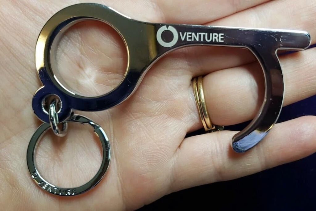 ontactless elevator button pusher, small handheld tool, key-shaped design, made of metal or plastic, used to press buttons without touch, hygiene accessory, COVID-19 safety tool