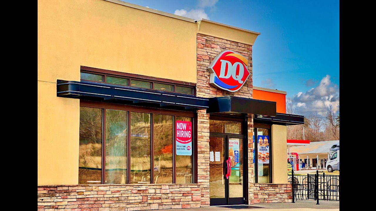 Dairy Queen restaurant with a red and blue DQ logo on the building’s brick facade, sunny day with clear skies