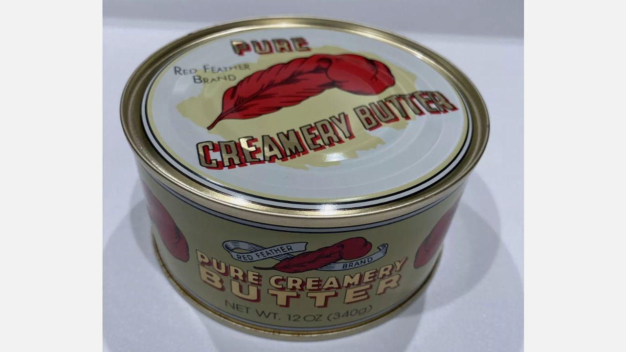 Red Feather brand Pure Creamery Butter in metal can, vintage-style label, 12 oz container, on white background