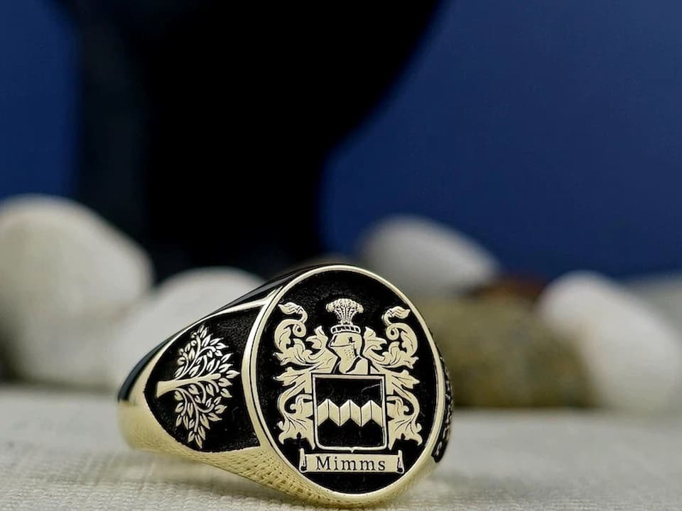 Gold ring, engraved family crest, intricate shield design, polished band, traditional heraldic symbols, vintage heirloom style