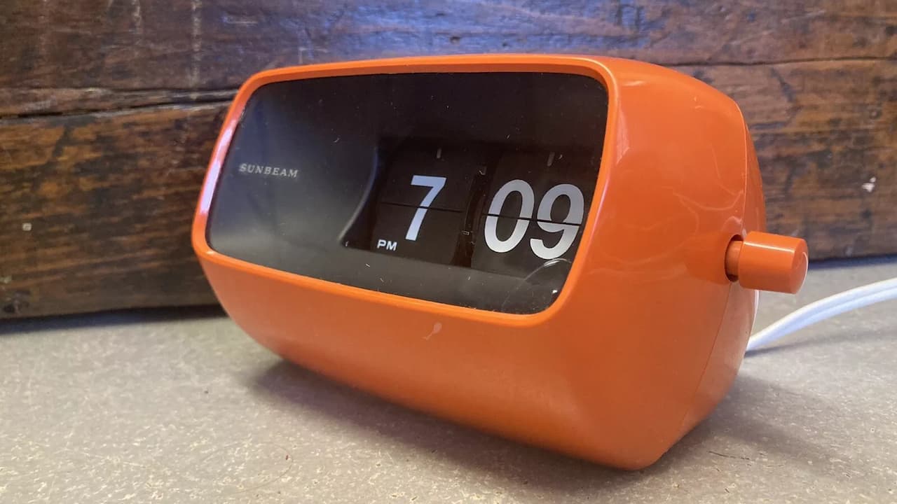 1960s flip clock, rectangular casing, large numeric display, mechanical flipping mechanism, bold black and white contrast, retro design