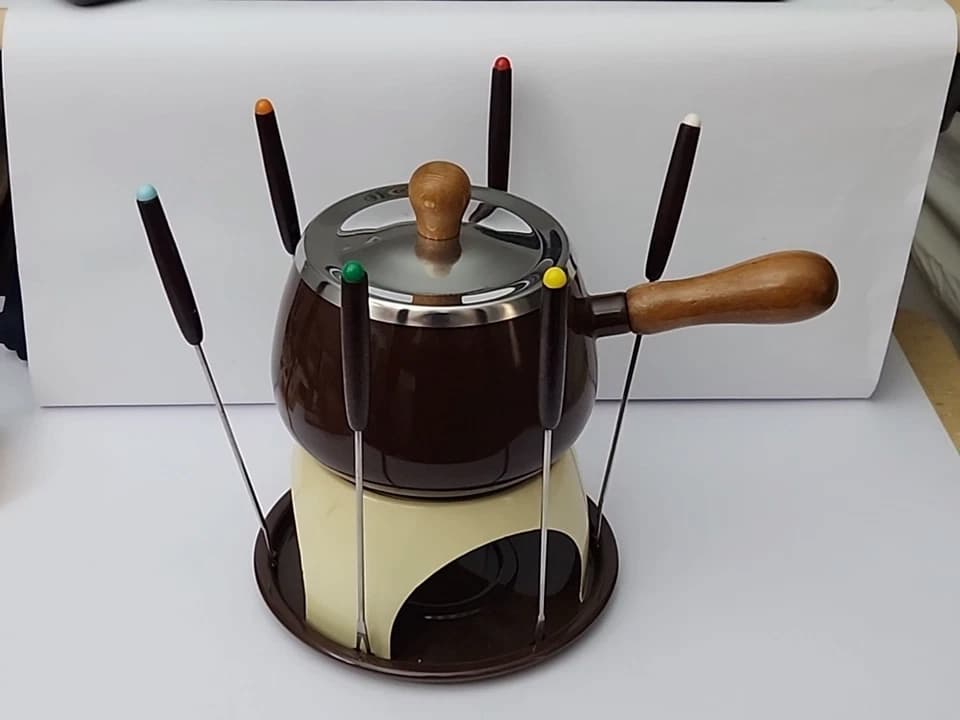 Used during a cozy dinner party, placed at the center of a vintage dining table, shared by friends on a cold evening, part of a retro-themed cooking class, featured in a nostalgic food magazine spread