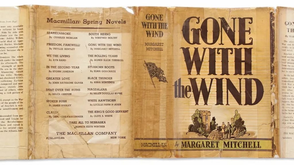 Dust jacket of the book "Gone With the Wind" by Margaret Mitchell, tan and yellow cover with bold black title text, illustration of a plantation scene at the bottom, back flap lists book reviews, spine displays title and author’s name