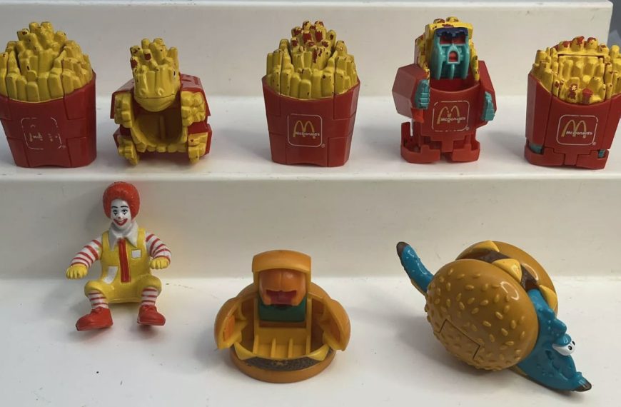 Collection of vintage McDonald’s Happy Meal Changeables toys, including robot fries, burgers, and a Ronald McDonald figure, displayed on white steps