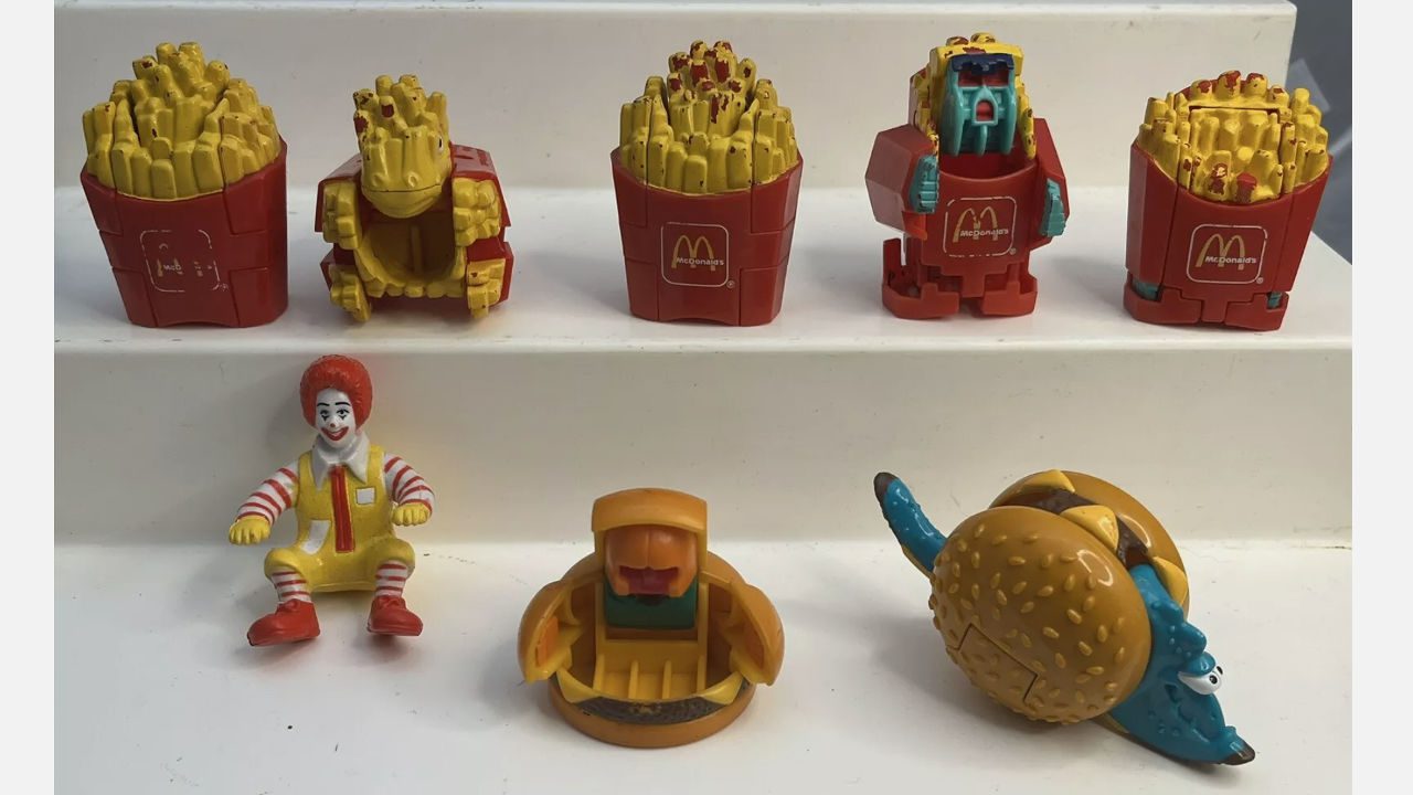 Collection of vintage McDonald’s Happy Meal Changeables toys, including robot fries, burgers, and a Ronald McDonald figure, displayed on white steps