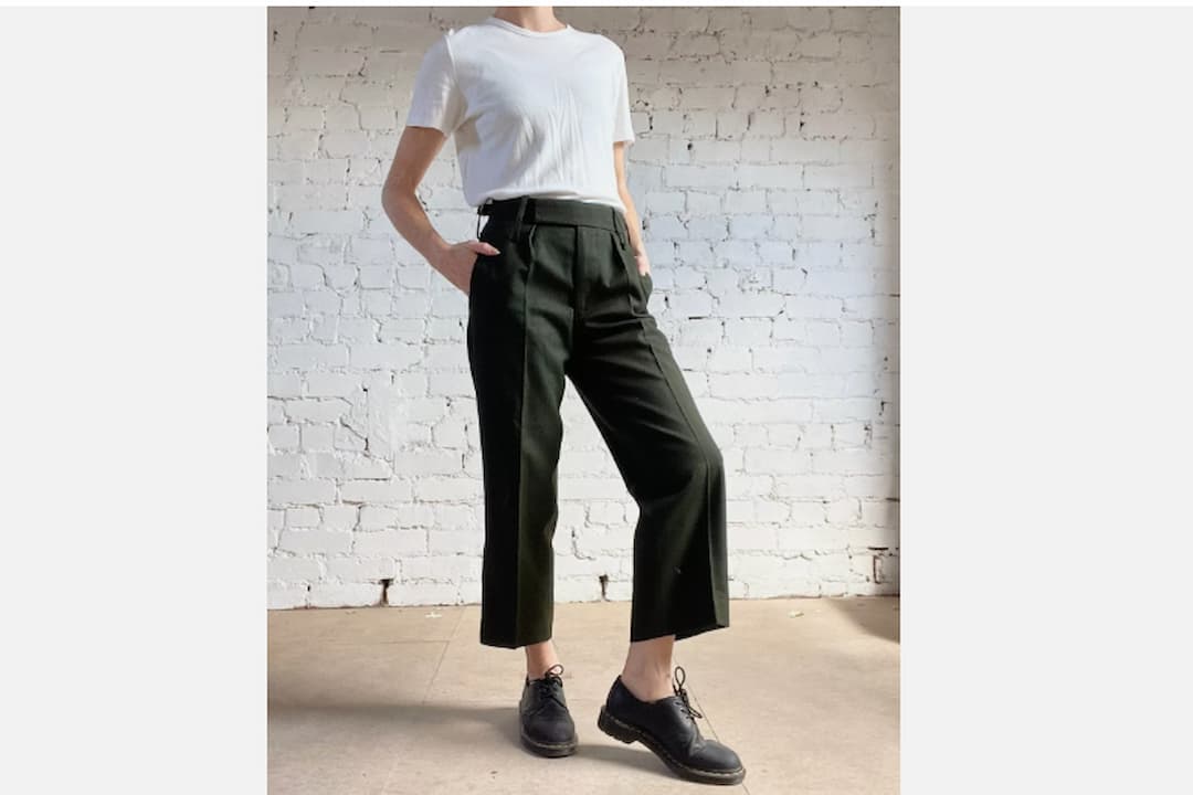 Black high-waisted pants, slim fit, front zipper, button closure, ankle-length cut, tailored design, soft fabric texture, classic wardrobe staple