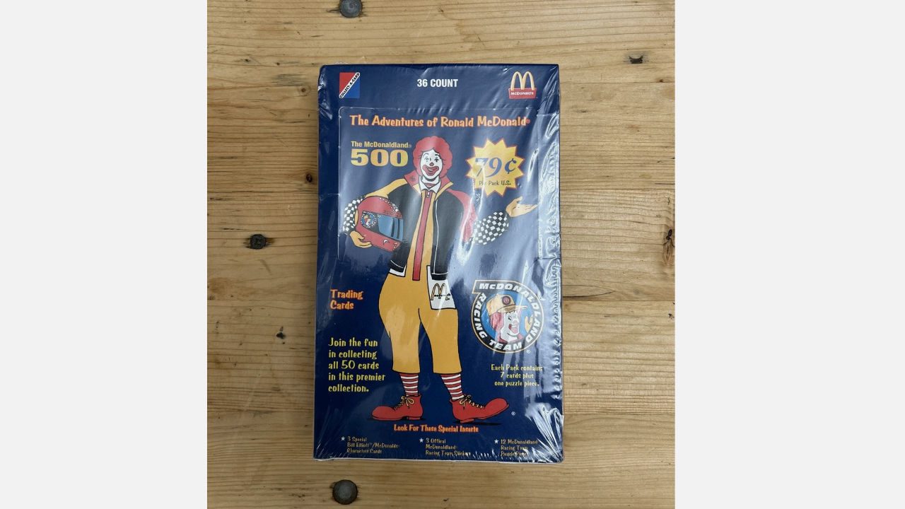Box of McDonald's "The Adventures of Ronald McDonald" trading cards featuring Ronald holding a racing helmet