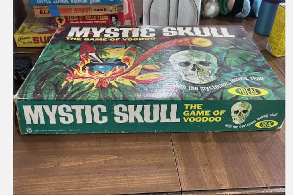 Mystic Skull board game box, featuring jungle artwork with a skull and glowing idol, labeled “The Game of Voodoo,” by Ideal, with tagline about a mysterious moving skull