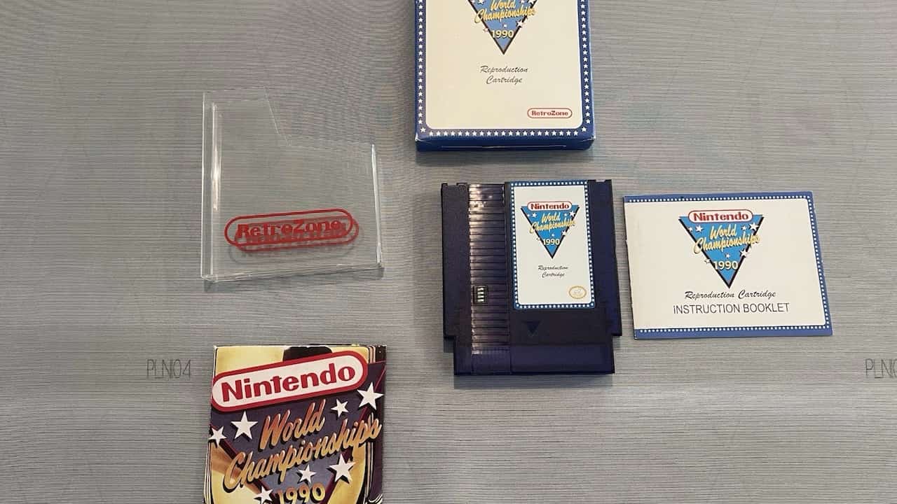 Nintendo World Championships 1990 reproduction cartridge, blue game cartridge, instruction booklet, original-style box, clear plastic case with RetroZone logo, and a commemorative booklet, laid out on a gray