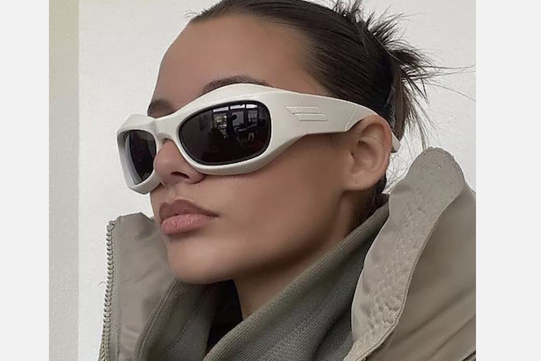 Oversized sunglasses, large rounded or square frames, tinted lenses, thick rims, bold fashion statement, retro-inspired design, displayed on a stand or worn on the face