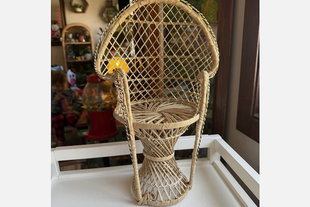 Peacock chair, large fan-shaped wicker backrest, intricate woven design, curved armrests, natural rattan material, bohemian vintage style, decorative and functional seating