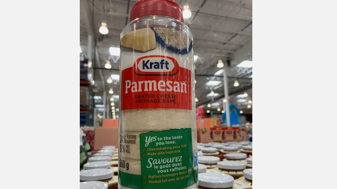 Kraft Parmesan grated cheese container, red cap, bilingual label, placed on store shelf in warehouse setting
