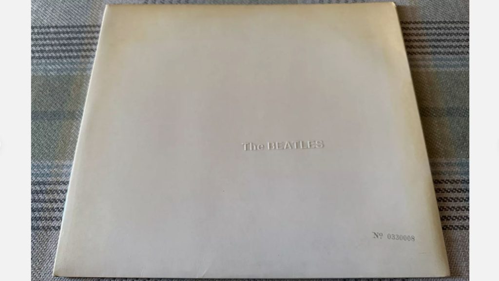 Rare edition of The Beatles' self-titled "White Album" with embossed band name and unique serial number No. 0330008 on a minimalist white cover