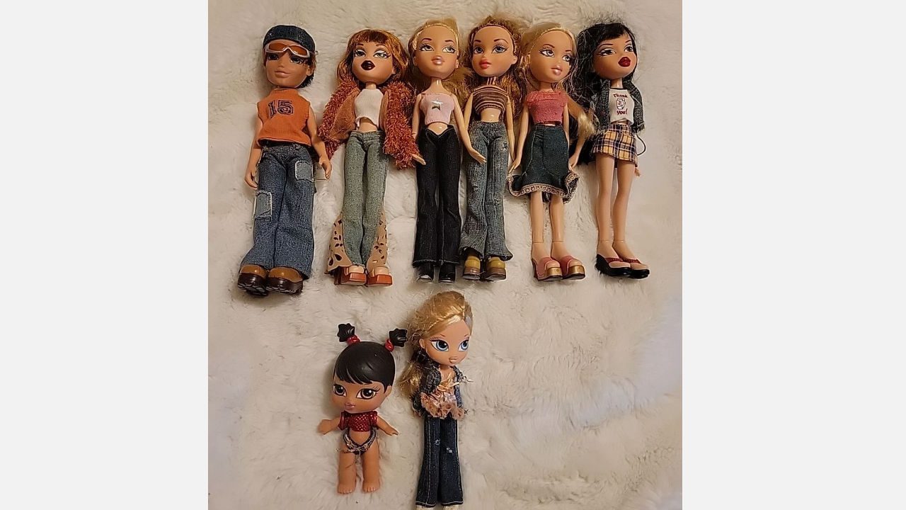 Seven vintage Bratz dolls, six standing and two smaller ones below, dressed in 2000s fashion, on white fur rug