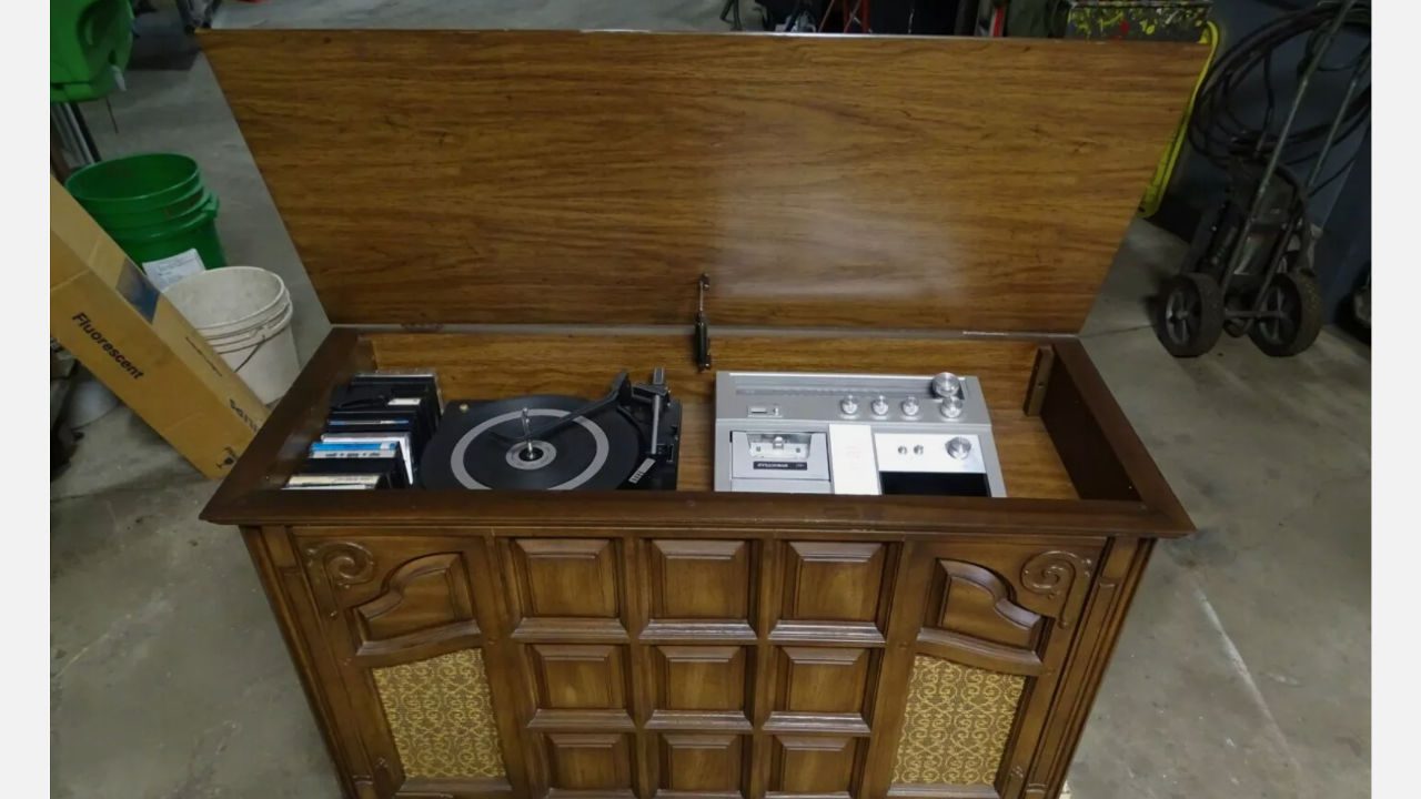 Vintage wooden record player console with built-in turntable, radio tuner, cassette deck, and storage space