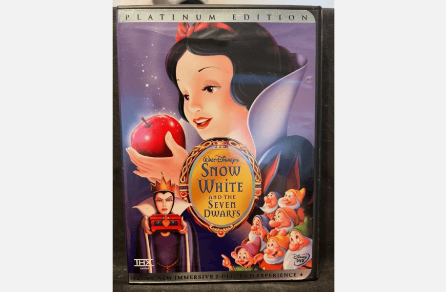 Snow White holding a red apple, VHS cover of Disney’s “Snow White and the Seven Dwarfs”, large gold sticker on the front, dwarfs gathered at the bottom, purple background, vintage Black Diamond Edition design