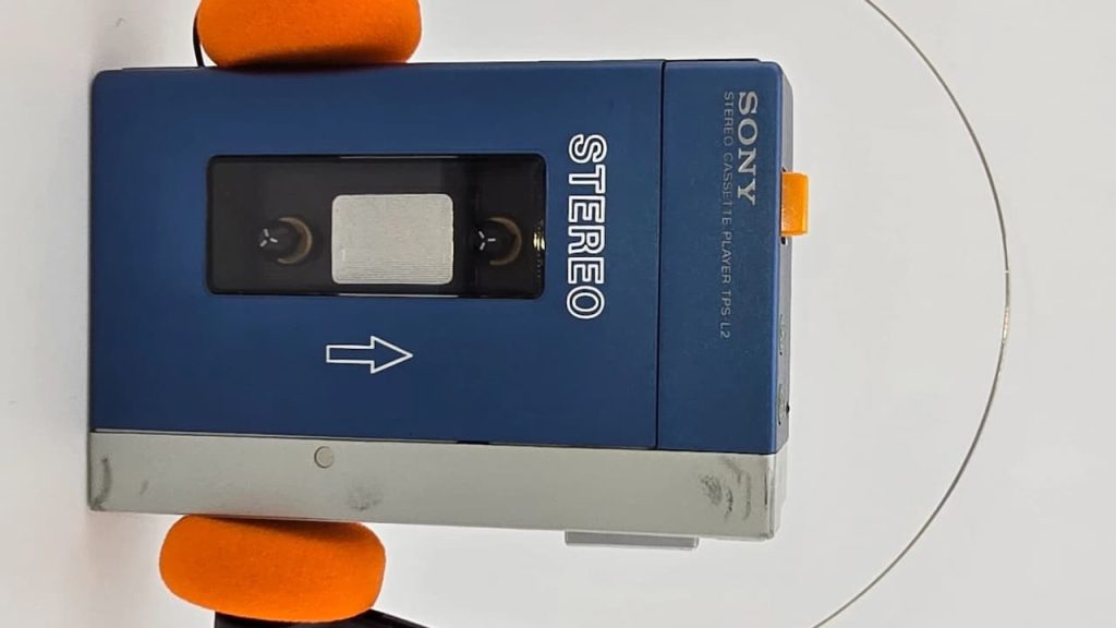 Sony Walkman TPS-L2, portable cassette player, retro design, blue and silver color, belt clip, headphone jack, control buttons, iconic 1980s audio device