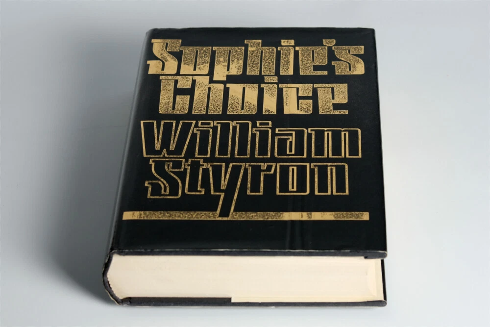 Sophie’s Choice by William Styron, paperback edition, black cover with sepia-toned photograph of a woman, bold white serif title text, author’s name in uppercase, vintage design, published by Vintage International