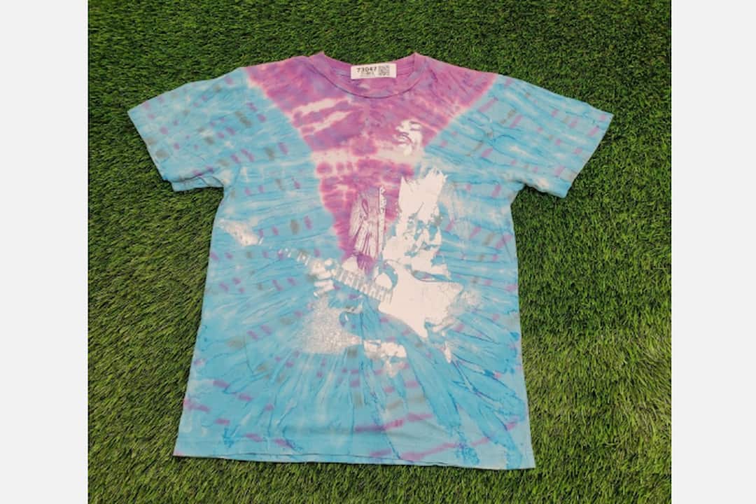 Tie-dye clothing, vibrant swirling patterns, multiple bright colors, cotton fabric, loose fit, retro 1960s-70s style, displayed on a hanger or worn casually