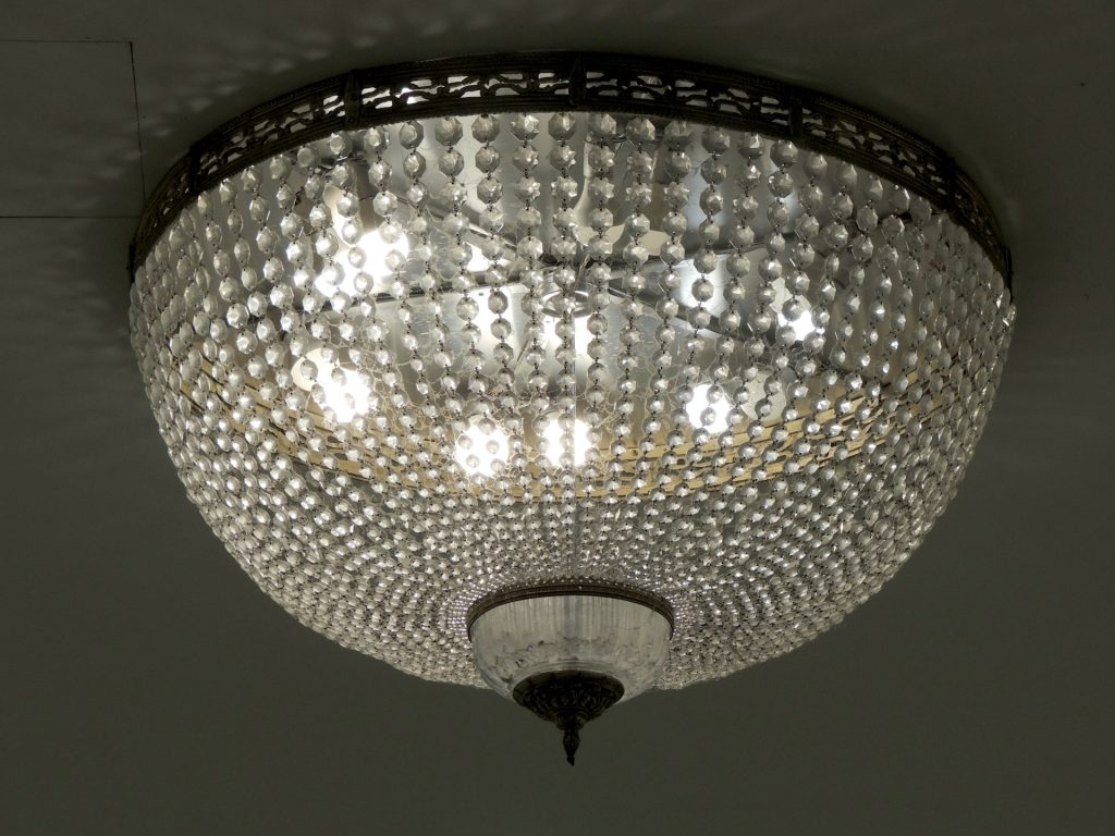 crystal ceiling light fixture, dome-shaped design, mounted on a dark ceiling, lit with multiple bulbs, elegant and vintage style, reflective glass elements
