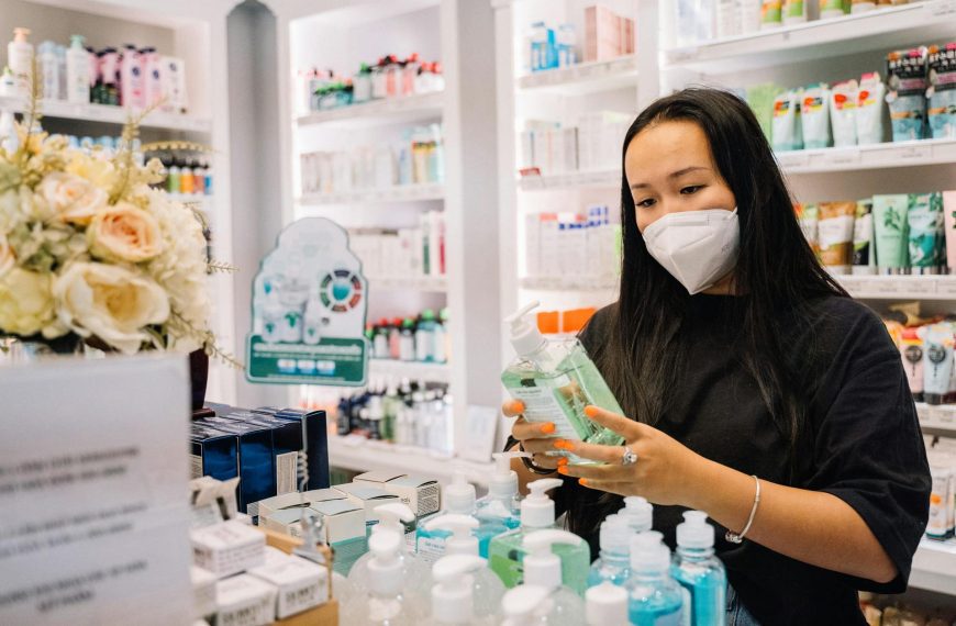 Woman in Black Shirt Holding A Hand Sanitizer Bottle