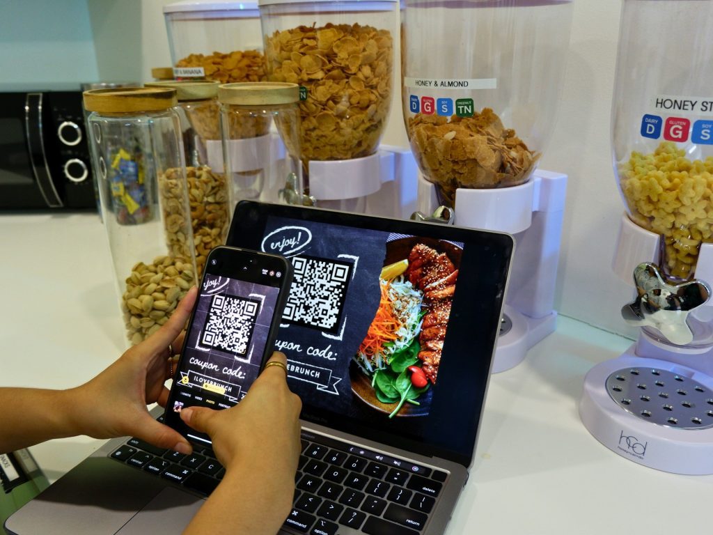 Scanning QR code to avail a restaurant's discount coupon.