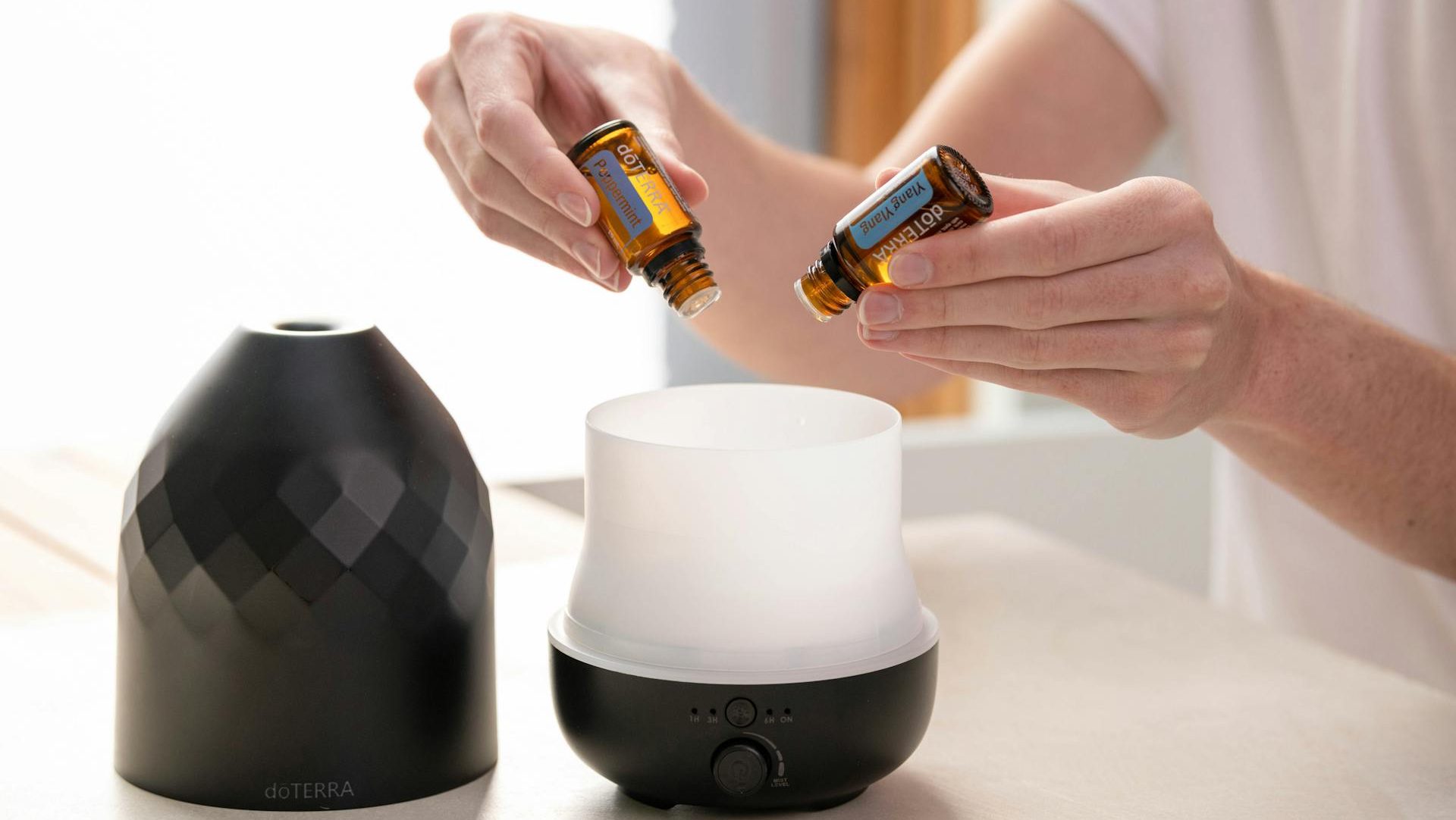 Person Putting Essential Oils into a Diffuser