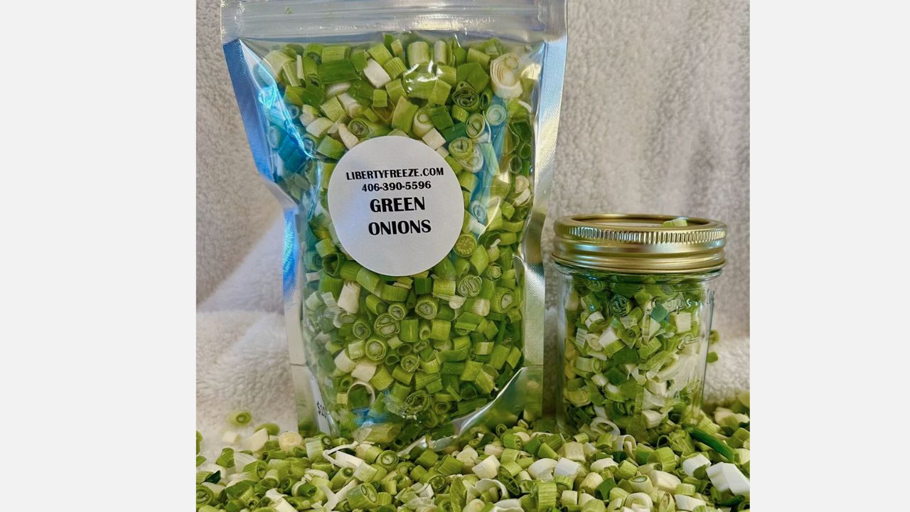 Freeze-dried green onions in a clear resealable bag and mason jar, with chopped pieces scattered around