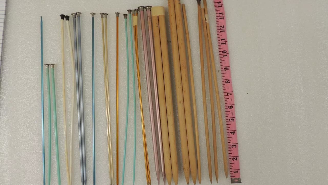 Knitting needles, smooth wood or metal, pointed tips, paired design, long and slender, used for crafting textiles
