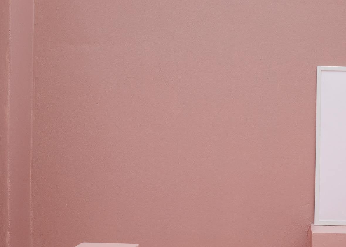 Empty frame placed on staircase in room with pink walls