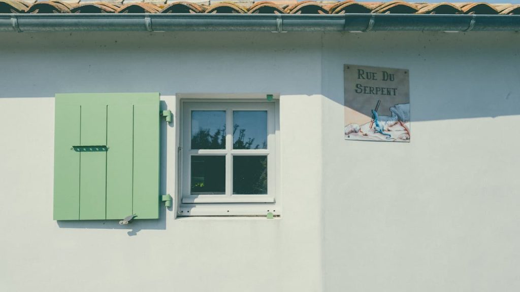 old single pane window, thin glass, wooden frame, peeling paint, visible condensation, rusted hinges, dirt-streaked surface