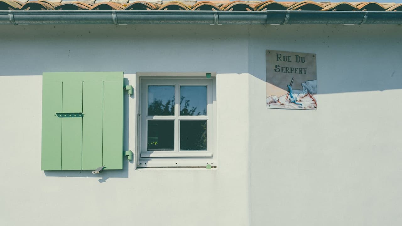 old single pane window, thin glass, wooden frame, peeling paint, visible condensation, rusted hinges, dirt-streaked surface