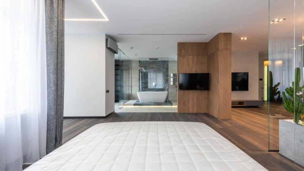 Modern minimalist interior with white walls, wood paneling, wall-mounted TV, glass partitions, tiled flooring